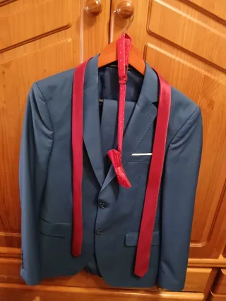 Traje de vestir azul con corbata roja y pajarita