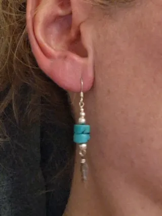 Pendientes plateados con turquesas y plumas.