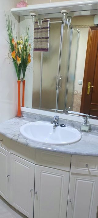Mueble de baño con lavabo, grifería y espejo