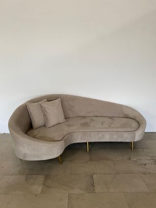 Sofá de terciopelo gris curvo