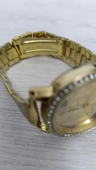 Reloj dorado con bisel de brillantes