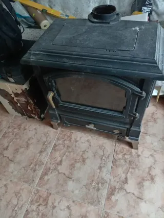 Estufa de leña negra con puerta de cristal