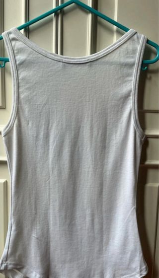 Camiseta blancqsin mangas con tachuelas y perlas