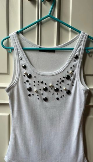 Camiseta blancqsin mangas con tachuelas y perlas
