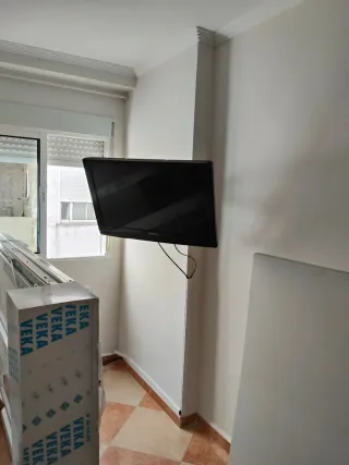 Televisor negro colgado en pared