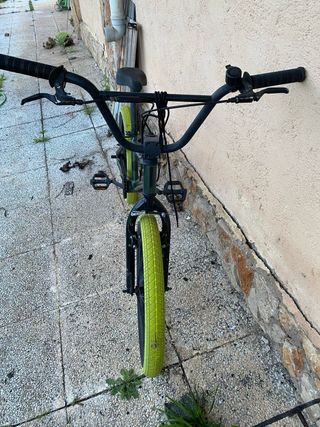 Bicicleta BMX verde con ruedas llamativas