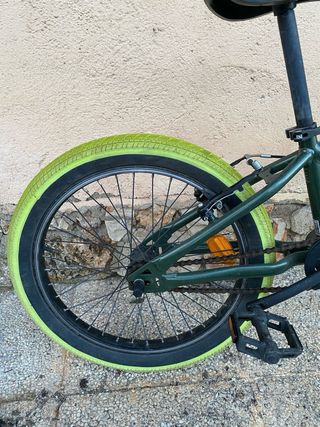 Bicicleta BMX verde con ruedas llamativas