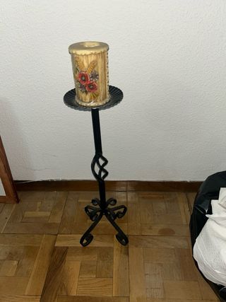 Candelabro de hierro forjado con vela.