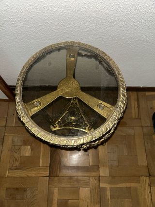 Mesita auxiliar dorada con tapa de cristal.