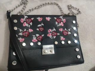 Bolso de mano negro con flores