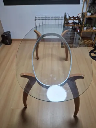 Mesa de cristal ovalada con patas de madera