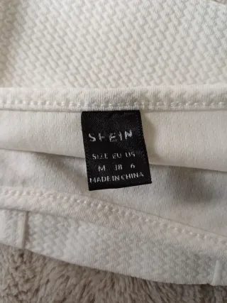 Top corto blanco con texto BOSTON