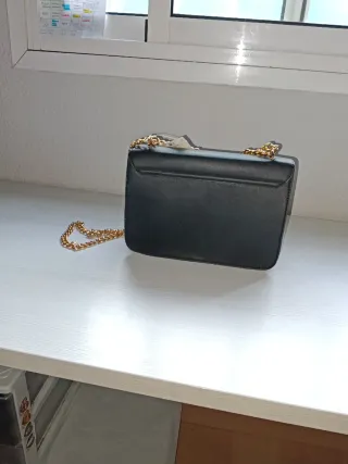 Bolso negro con bordado floral y cadena dorada