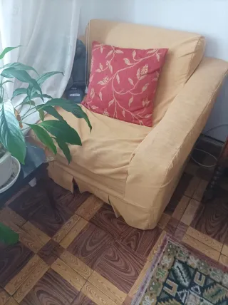 Sofá tela amarillo con cojín rojo