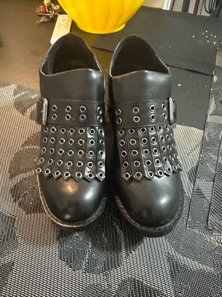 Scarpe nere con frange e borchie stile mocassino