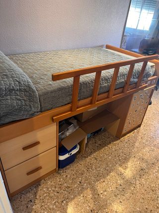 Cama alta con cajones y escalera y baranda .