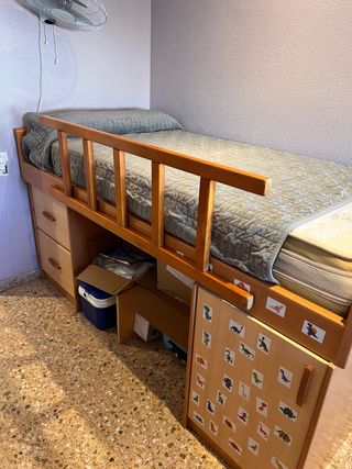 Cama alta con cajones y escalera y baranda .