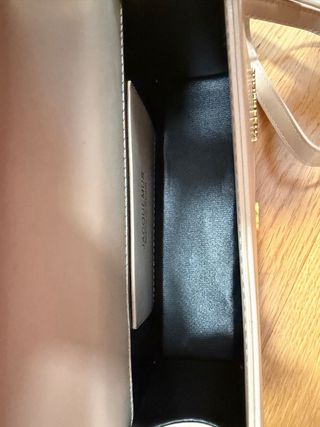 Bolso beige elegante con logo dorado tipo mini bag