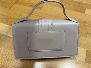 Bolso beige elegante con logo dorado tipo mini bag