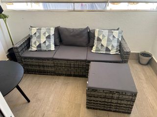 Sofá de exterior gris con cojines