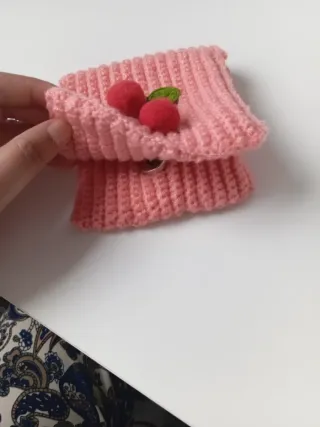 Cartera tejida con cerezas y etiqueta 'Handmade'