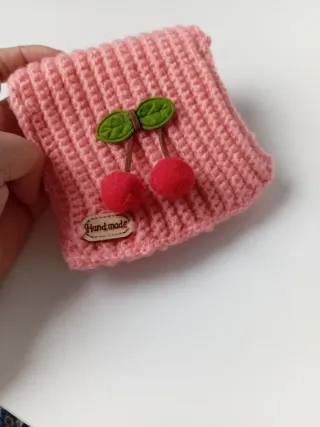 Cartera tejida con cerezas y etiqueta 'Handmade'