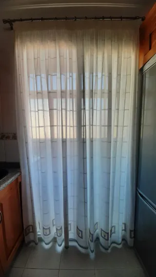 Cortina decorativa blanca y greca de colores.