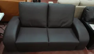 Sofá marrón piel sintética, patas metálicas.