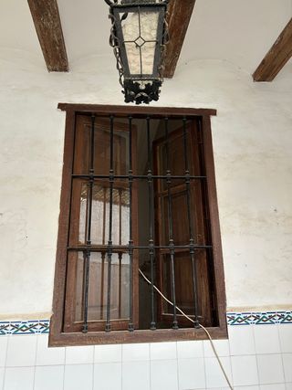 Ventana antigua de madera con reja