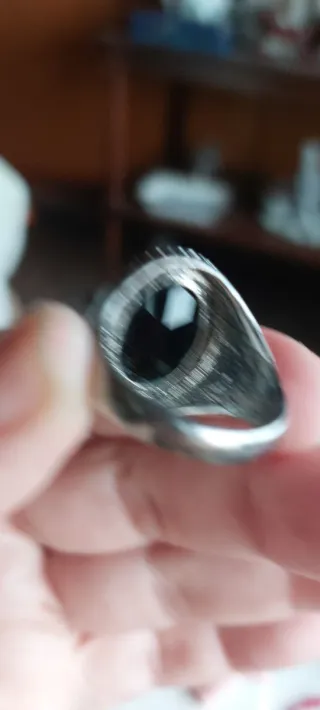 Anillo de acero con piedra negra.