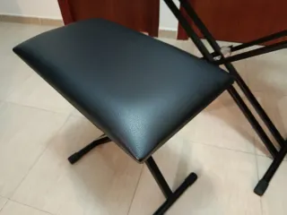 Teclado electrónico con soporte y banqueta.