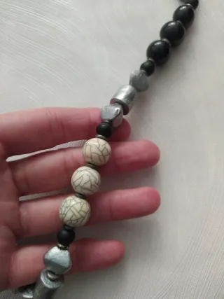 Collar largo de cuentas negras, marfil y gris.
