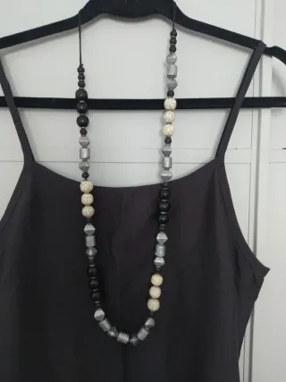 Collar largo de cuentas negras, marfil y gris.