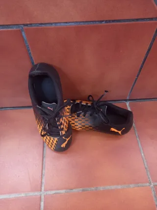 Botas de fútbol Puma negras y naranjas