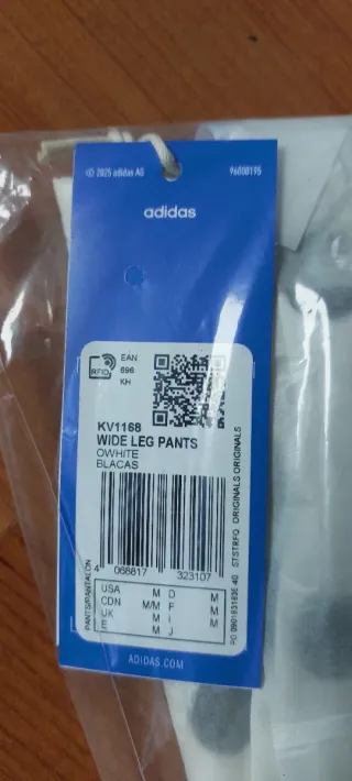 Pantalones Adidas blanco con lunares negros.