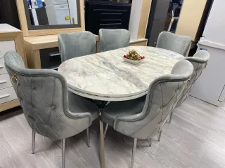 Mesa de comedor ovalada y sillas de terciopelo