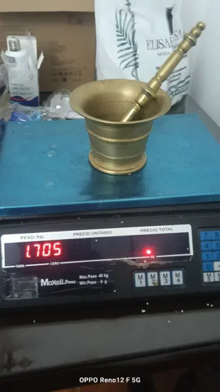 Antiguo mortero de bronce con mano