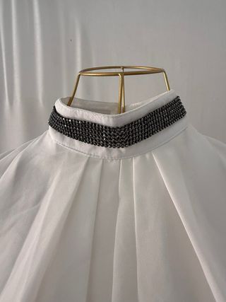 Blusa blanca con cuello alto y detalles