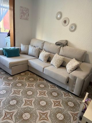 Sofá modular beige y cojines y puff