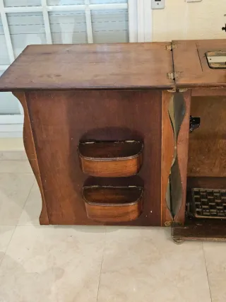 Máquina Singer en mueble decorativo.