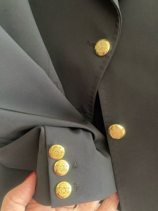 Blazer blu scuro con bottoni in metallo dorato.