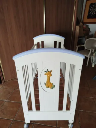 Cuna de bebé blanca con jirafa