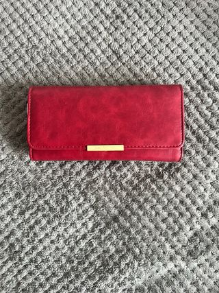 Cartera dorada con logo metálico