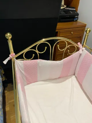 Cuna de bebé metálica con protector rosa y colchón