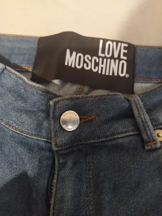 Jeans donna moschino con cuore alla caviglia .