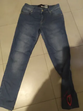 Jeans donna moschino con cuore alla caviglia .