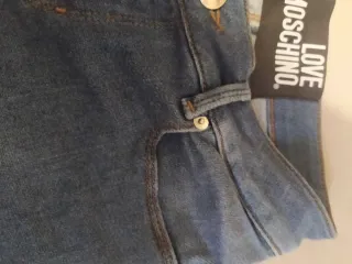 Jeans donna moschino con cuore alla caviglia .