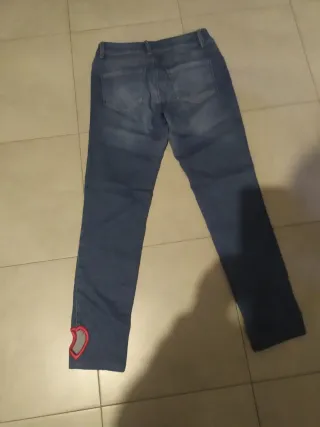 Jeans donna moschino con cuore alla caviglia .