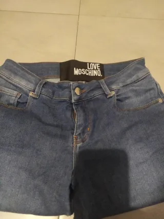 Jeans donna moschino con cuore alla caviglia .