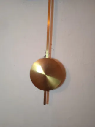 Reloj de pared con péndulo dorado